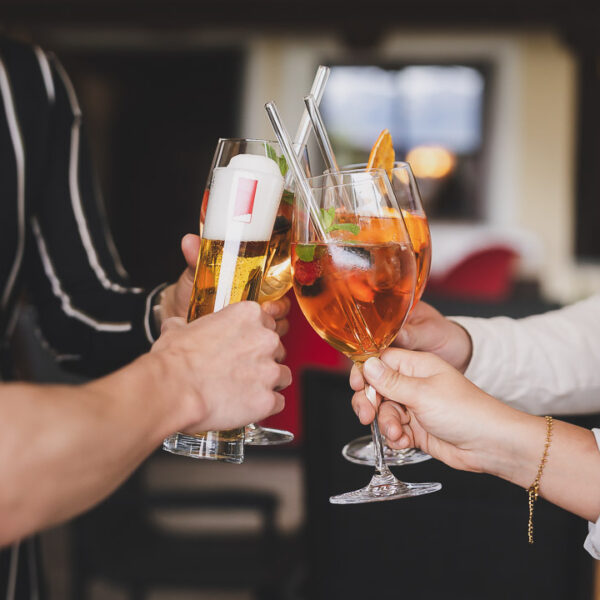 Gruppe beim Anstoßen mit vielfältigen Drinks im Dorfstadl